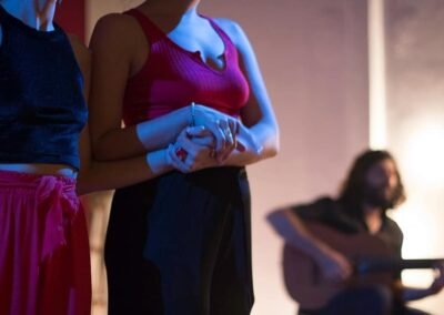 Dos jovenes agarradas con un guitarrista de fondo