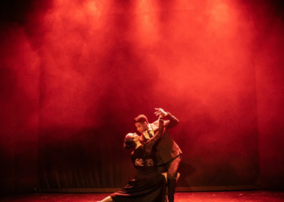 Escenario con una pareja central bailando tango