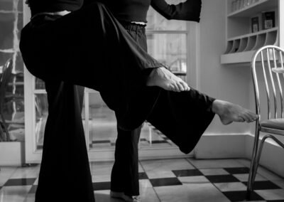 Natalia Puccioni y acompañante bailando tango en banco y negro