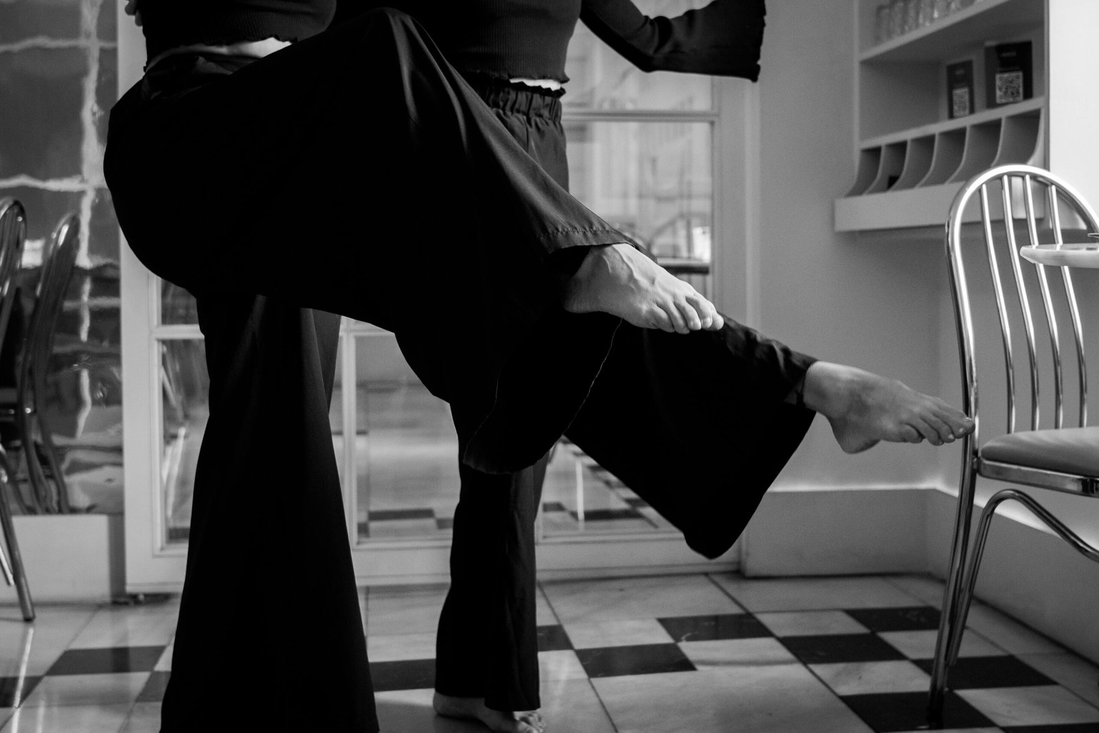 Natalia Puccioni y acompañante bailando tango en banco y negro